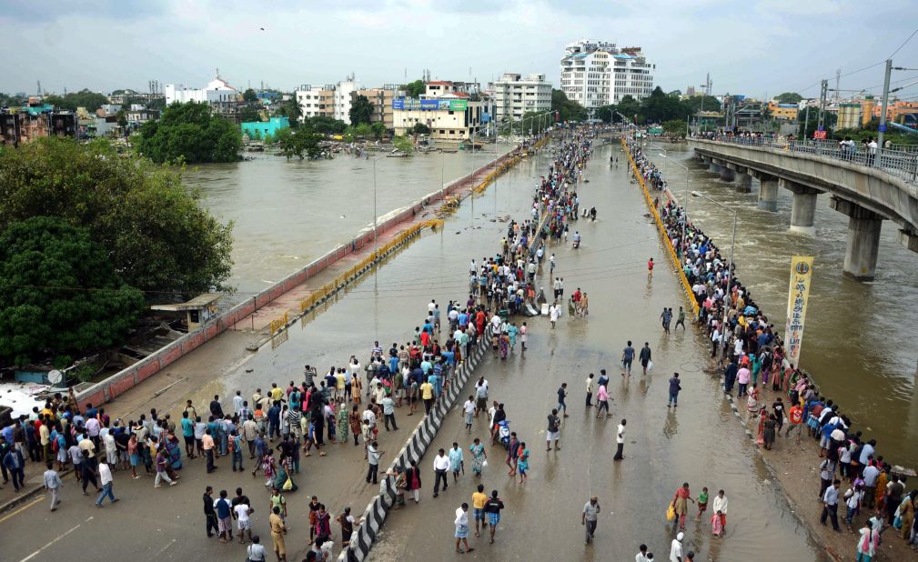 Residents look at flood water on a major highway in Chennai on December 3.