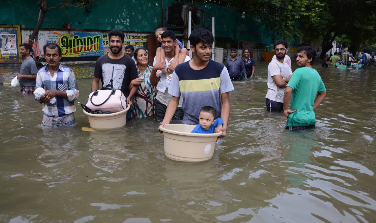 Indian residents carry children and possessions as they walk through flood waters in Chennai  December 3.
