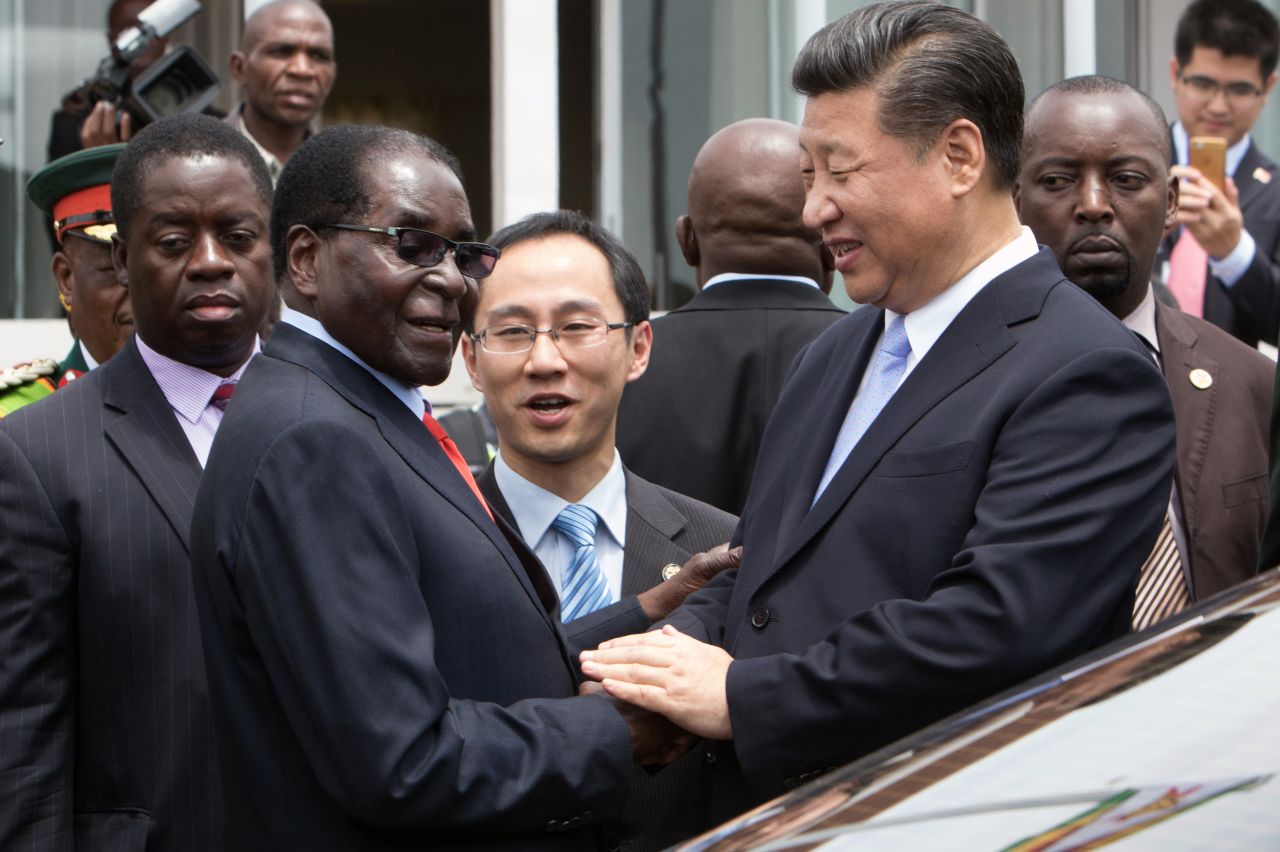 China's President Xi Jinping (2nd R) shakes  hands  with Zimbabwe's President Robert Mugabe (2nd L) as he arrive on December 1, 2015 in Harare. China's President Xi Jinping visited Zimbabwe on December 1 on a rare trip by a world leader to a country shunned by Western powers over President Robert Mugabe's widely-criticised record on human rights. The two leaders held talks and oversaw the signing by their ministers of 10 agreements and memorandums of understanding covering energy, aviation, telecommunications and investment promotion deals to shore up Zimbabwe's economy, which has fallen into dire straits under Mugabe's rule.