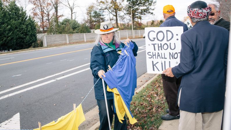 Kris Gregory, 56, from Falls Church, Virginia, gathers up shirts that display the names and ages of victims of the Navy Yard shooting that took place in Washington on September 13, 2013. 