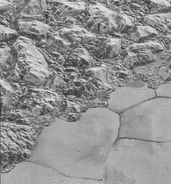 When NASA's New Horizons spacecraft flew past Pluto in July 2015, it captured this image of the major mountain ranges where it meets a vast icy plain called Sputnik Planitia. The ridges in these photos have now been identified as dunes made of solid methane ice grains. 
