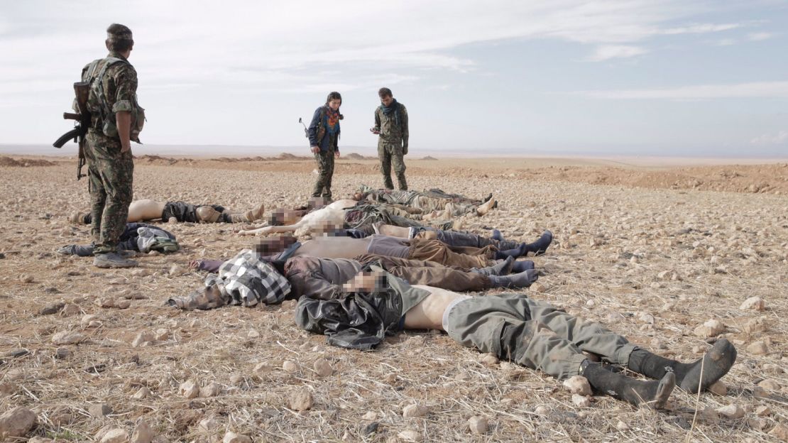 After battle, Kurdish fighters -- women among them -- secure the area after checking dead ISIS fighters for suicide vests.