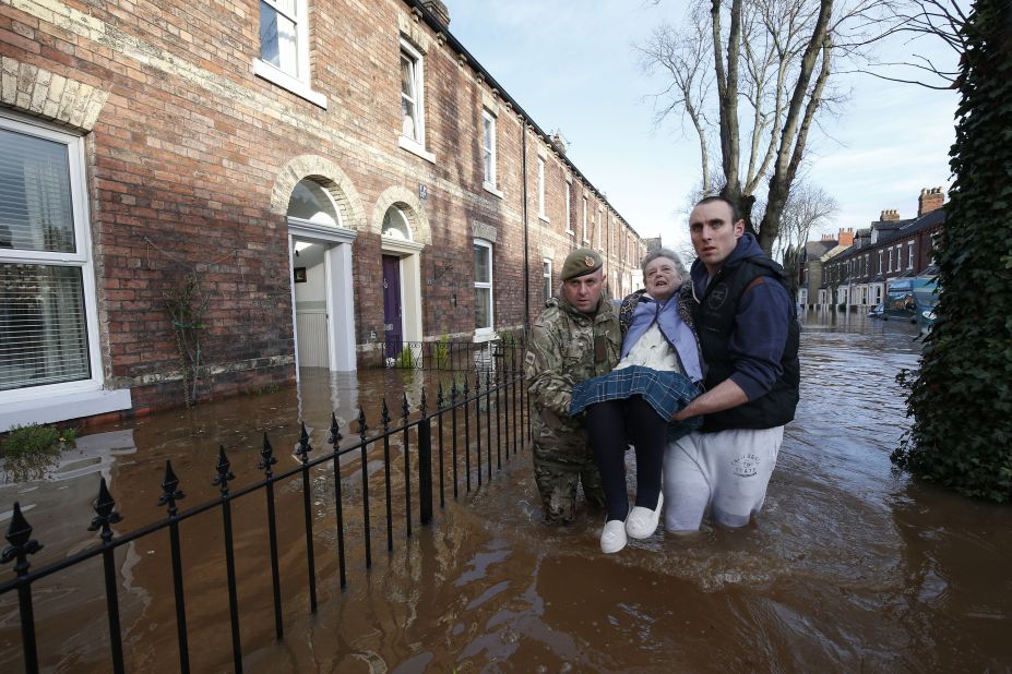 Margaret McCraken, 79, is helped from her home in Carlisle, northern England on December 6, 2015 by members of the armed forces. Storm Desmond whipped across Britain at the weekend, bringing heavy rain, strong winds and flooding to parts of the country.