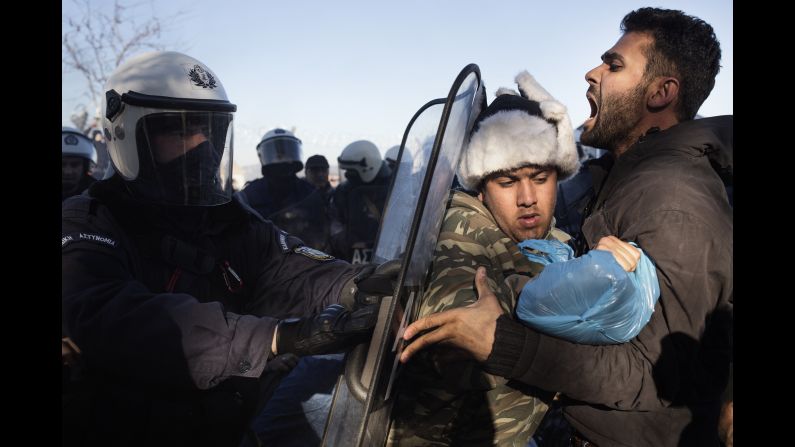 Greek anti-riot police try to remove a group of migrants at the border on December 4. Only Syrians, Afghans and Iraqis are permitted to enter neighboring Macedonia. Immigrants from places like Iran and Pakistan are rejected.