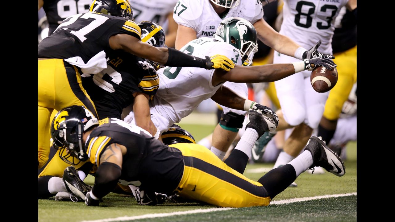 Michigan State running back LJ Scott reaches over the goal line to score the go-ahead touchdown in the Big Ten Championship game on Saturday, December 5. The 1-yard run came with 27 seconds left and capped a nine-minute, 22-play drive. The Spartans defeated Iowa 16-13 and booked a spot in the College Football Playoff.
