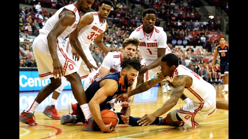 Virginia's Anthony Gill is surrounded by Ohio State players as they battle for a loose ball Tuesday, December 1, in Columbus, Ohio.
