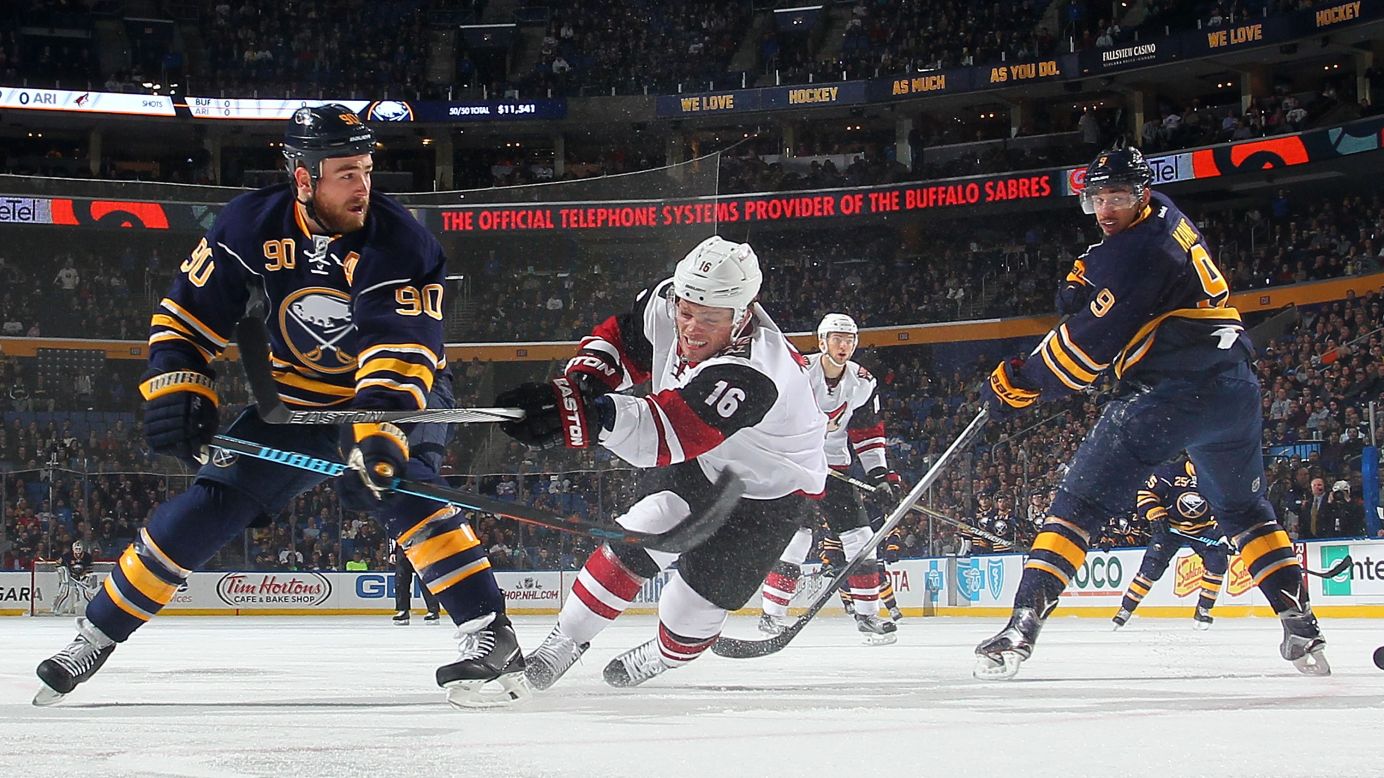 Arizona's Max Domi, center, competes against Buffalo's Ryan O'Reilly during an NHL game in Buffalo, New York, on Friday, December 4.