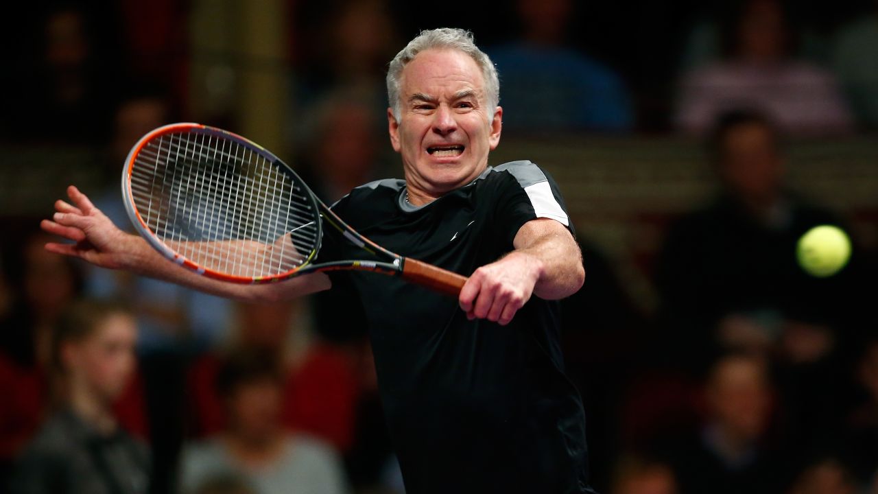 Tennis great John McEnroe plays a backhand shot while taking on Tim Henman in London on Saturday, December 5.