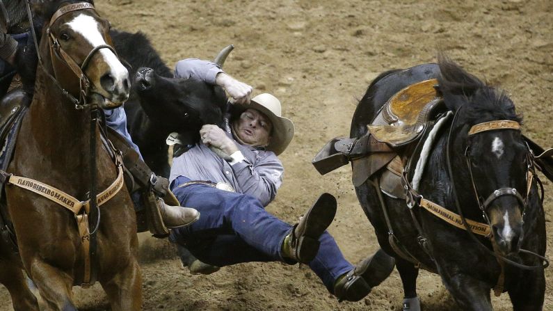 Hunter Cure wrestles a steer Thursday, December 3, during the National Finals Rodeo in Las Vegas. He tied for third in the event.
