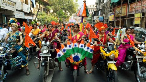Indian women dressed in traditional attire drive motor-cycles as they take part in a procession celebrating 'Gudhi Padwa' or the Maharashtrian new year in Mumbai on March 21, 2015.  Gudhi Padwa is the Hindu new year for the people of Maharashtra state and marks the end of a harvest and the beginning of a new one, which for an agricultural community signifies the beginning of a new year.  AFP PHOTO / PUNIT PARANJPE        (Photo credit should read PUNIT PARANJPE/AFP/Getty Images)