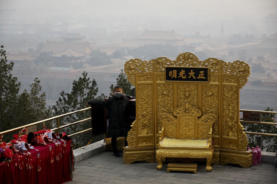 A mask-wearing vendor awaits customers at the Jingshan Park on a polluted day in Beijing on December 7.