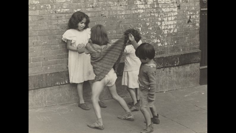 A child in New York City lifts a girl's dress circa 1940. This shot was taken by American photographer Helen Levitt (1918-2009).