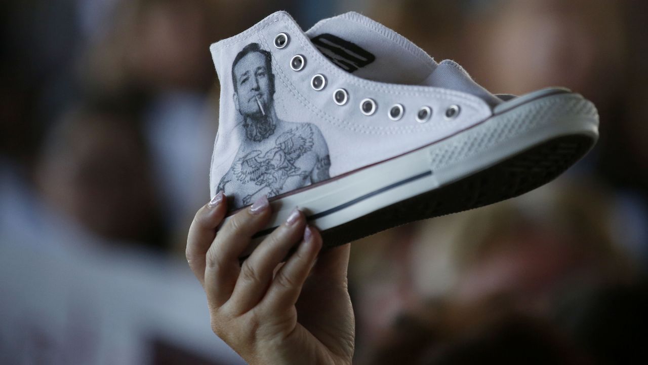 A supporter of Republican presidential candidate Ted Cruz holds up a sneaker with the U.S. senator's likeness on it while Cruz campaigns in Fort Worth, Texas, on Thursday, September 3.
