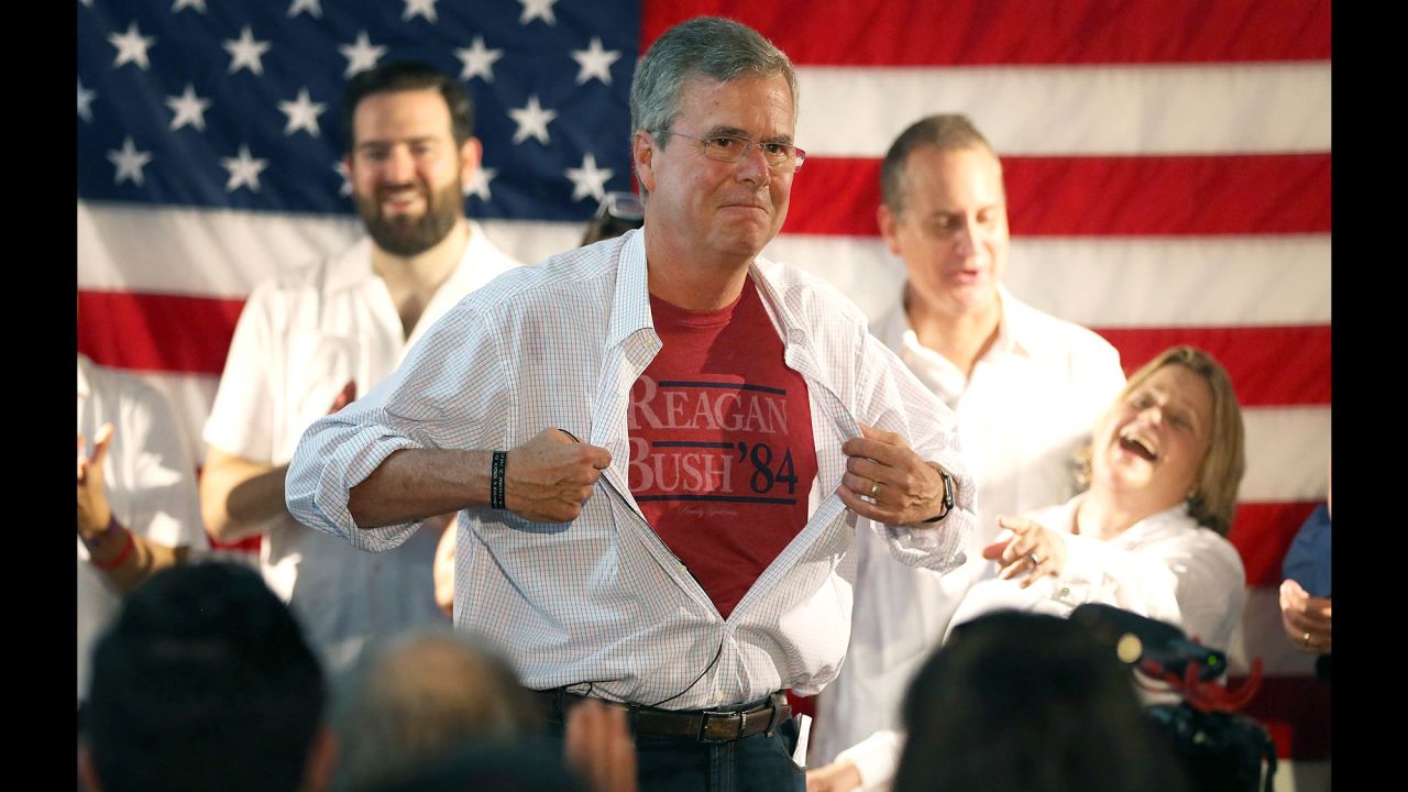 Republican presidential candidate Jeb Bush shows off a Reagan-Bush '84 T-shirt as he speaks during a Miami field office opening on Saturday, September 12.