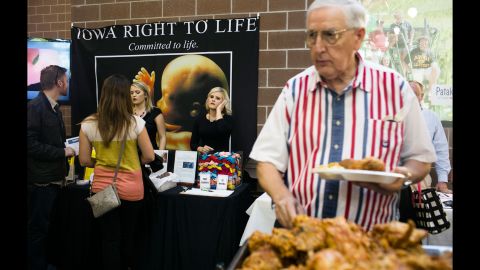 A man helps himself to a fried-chicken buffet near an anti-abortion display Saturday, September 19, at the Iowa Faith & Freedom Coalition's <a href="http://www.cnn.com/interactive/2015/10/politics/fear-voting-christian-right/" target="_blank">Fall Family Dinner</a> in Des Moines.