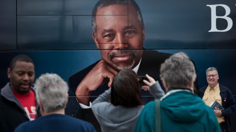 Supporters of Republican presidential candidate Ben Carson stand in front of his tour bus at a book signing in Edmond, Oklahoma, on Wednesday, October 21.