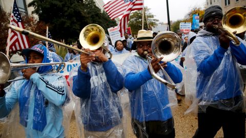Trombonists lead the way as Senate contract cooks and cleaning workers march for higher wages near the U.S. Capitol on Tuesday, November 10.