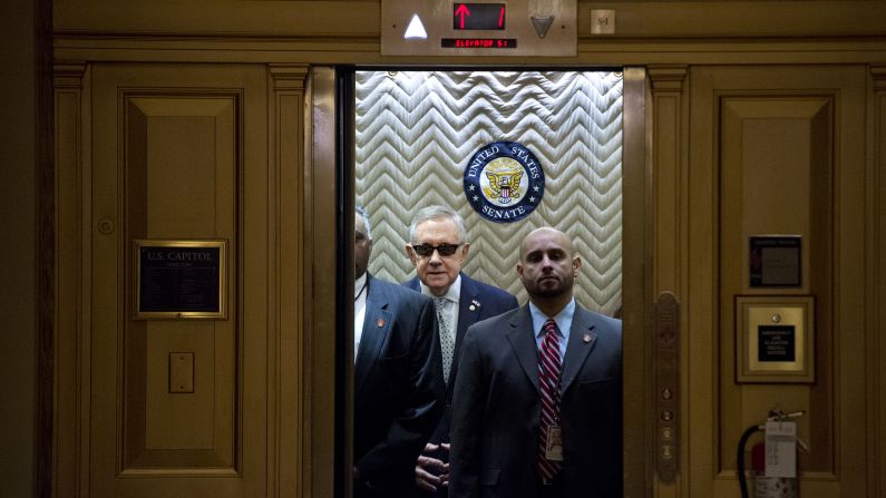 Senate Minority Leader Harry Reid, in the sunglasses, boards an elevator at the Capitol after signing a condolence book Tuesday, November 17, for victims of the Paris terrorist attacks.