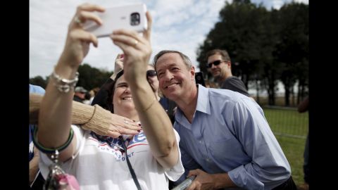 Someone tries to cover up the Bernie Sanders T-shirt on a woman taking a selfie with another Democratic presidential candidate, Martin O'Malley, on Saturday, November 21. O'Malley, a former governor of Maryland, was attending the annual Blue Jamboree event in North Charleston, South Carolina.