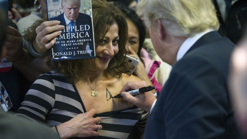 Republican presidential candidate Donald Trump signs a supporter's chest during a campaign rally in Manassas, Virginia, on Wednesday, December 2.