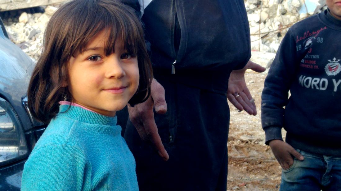 A young resident of Kobani. She stood by her father, Mustafa Ismail, who watched silently for hours as a bulldozer hauled away the remains of his three-story house.