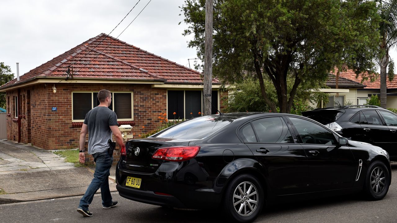 Police officers are seen outside a house in a southwestern suburb of Sydney after conducting a number of raids around the city