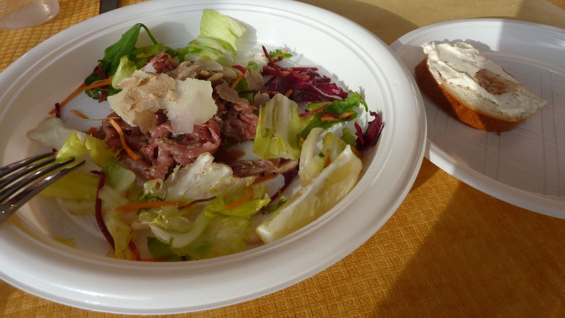 Carpaccio of Tuscan Chianina beef, seasoned with lemon juice, salt and pepper, and served with valeriana salad, pine nuts and shavings of white truffle and Parmesan. On the side, white bread spread with soft mascarpone cheese and topped with a sliver of truffle.