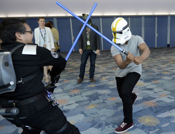 "The Force Awakens" cast member John Boyega wearing a Stormtrooper helmet to disguise his identity engages a unknowing fan in a lightsaber dual during the kick-off event of Disney's Star Wars Celebration 2015.