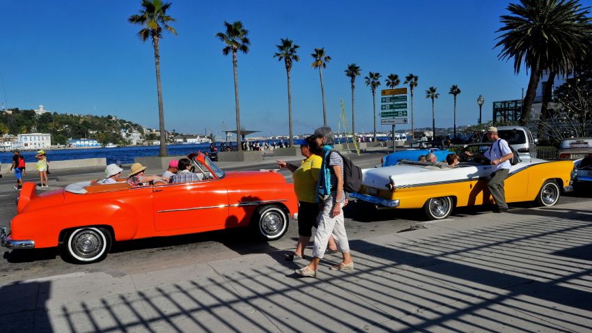 TO GO WITH AFP STORY by Rigoberto Diaz
Tourists from the United States are seen in old American cars in Havana, on April 6, 2015. With sanctions easing, Cuba is bracing for what could be a surge in visitors that could overwhelm its small tourism industry. Americans are starting to discover Cuba, though from them, travel to the island remains limited for now to persons with Cuban relatives or those visiting in a handful of categories such as for academic, sport, religious or cultural purposes. Washington and Havana have been moving toward normalizing relations after more than 50 years of US economic sanctions and are in talks on reopening embassies.  AFP PHOTO / YAMIL LAGE        (Photo credit should read YAMIL LAGE/AFP/Getty Images)