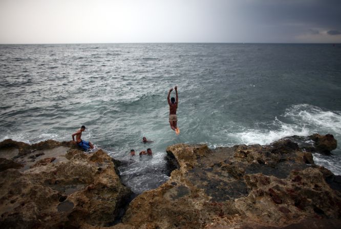 Locals swim along the Malecon coastal area in Havana.