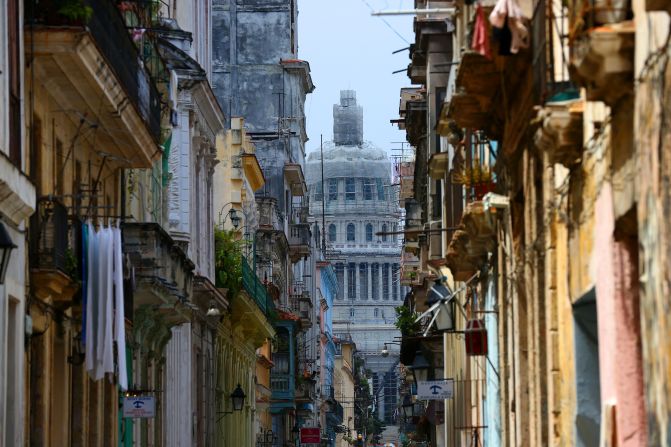 U.S. travelers are eager to visit Cuba to see what they've been missing. Here, a street in Havana provides a peek at the National Capitol Building.