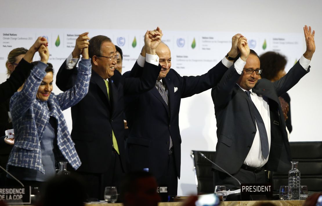 French President François Hollande, right, U.N. chief Ban Ki-moon, second from left, and others celebrate.