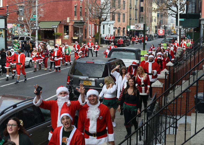 People dressed as Santa Claus and in other holiday-related outfits start the SantaCon parade after meeting in Brooklyn's McCarren Park in New York City.