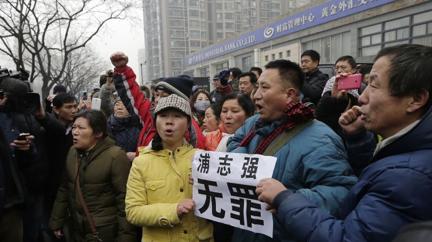 Supporters of prominent rights lawyer Pu Zhiqiang chant slogans as they gather near the Beijing Second Intermediate People's Court in Beijing, Monday, Dec. 14, 2015. Pu went on trial Monday on charges of provoking trouble with commentaries on social media that were critical of the ruling Communist Party. The placard reads: "Pu Zhiqiang, innocence." (AP Photo/Andy Wong)