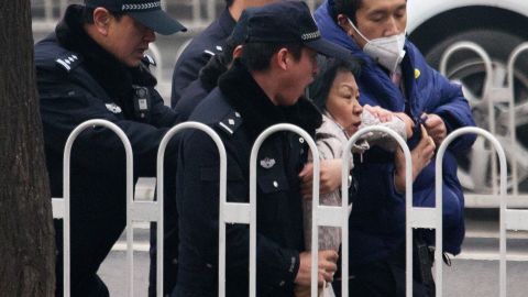Police officers take away a supporter of Pu Zhiqiang.