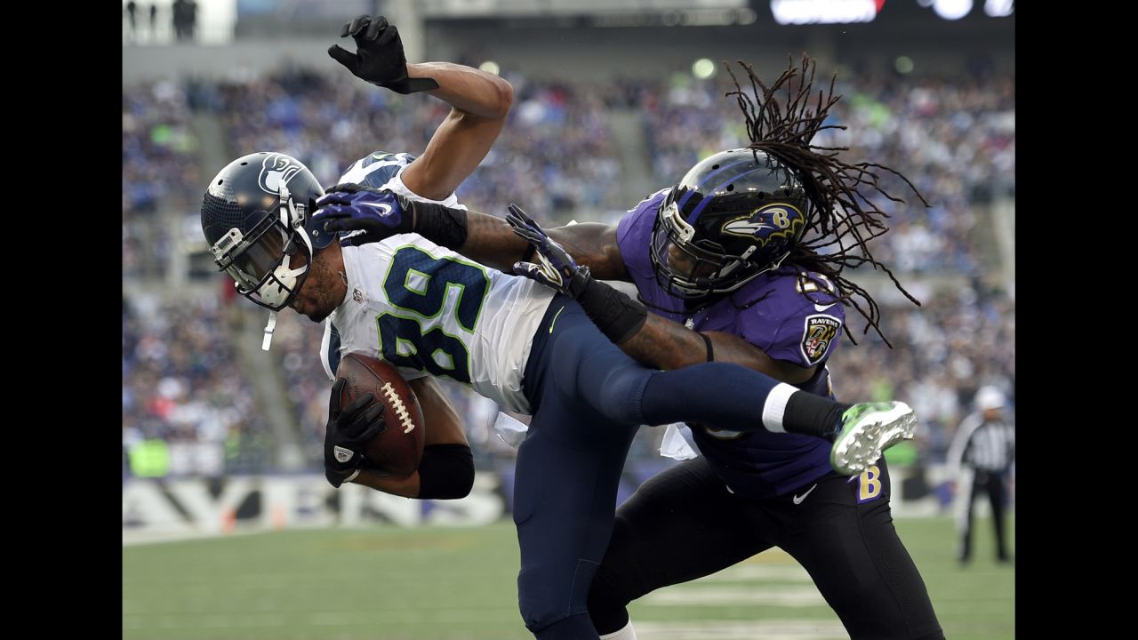Seattle wide receiver Doug Baldwin, left, is hit by Baltimore's Kendrick Lewis during an NFL game in Seattle on Sunday, December 13. Baldwin scored on the play -- one of three touchdowns he had in the 35-6 drubbing.