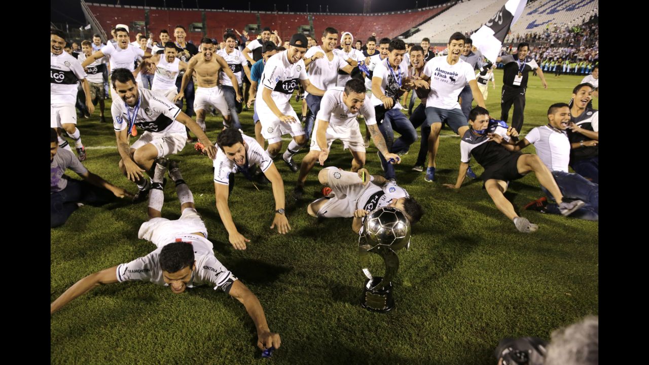 Olimpia players celebrate Wednesday, December 9, after defeating Cerro Porteno to win the Apertura playoff final in Asuncion, Paraguay.