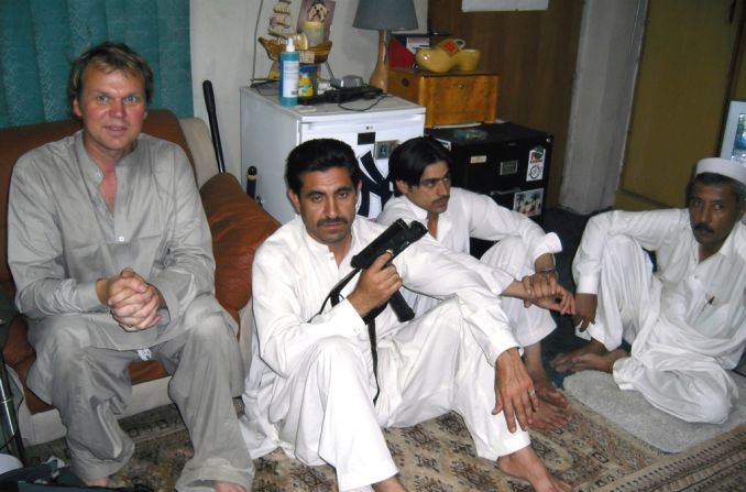 2009: A chance encounter with a forger in Kandahar, Afghanistan, led to a smuggler's bazaar. Drury is pictured here with some of the traders. 