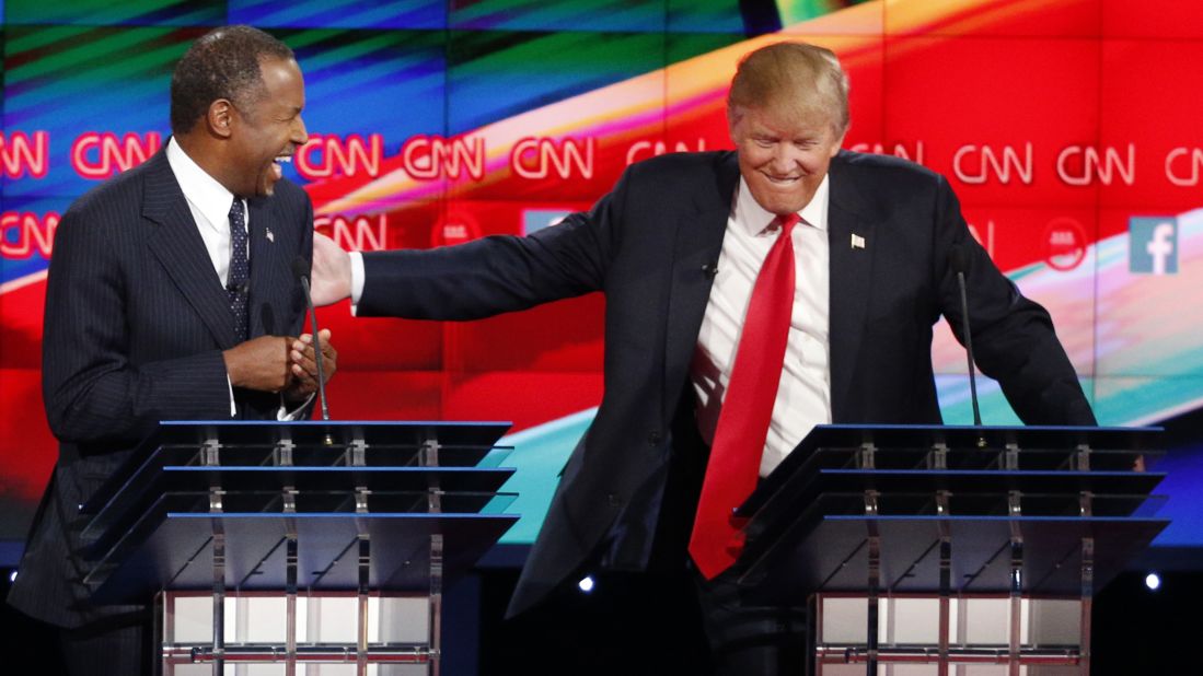 Carson and Trump share a laugh on stage.
