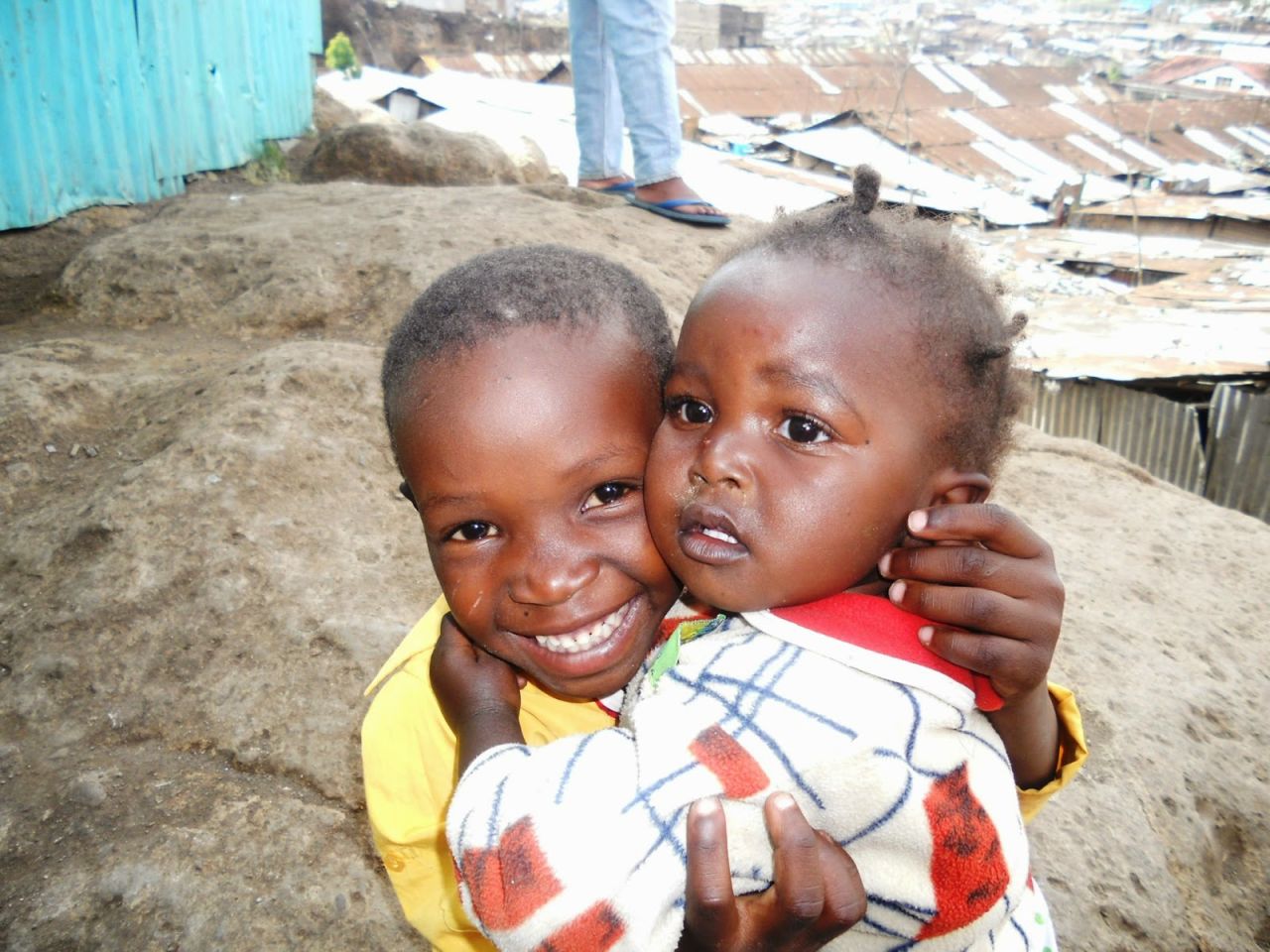 This photograph of two siblings clutching each other in an embrace shows that love endures in the slums, despite the other evident hardships. 
