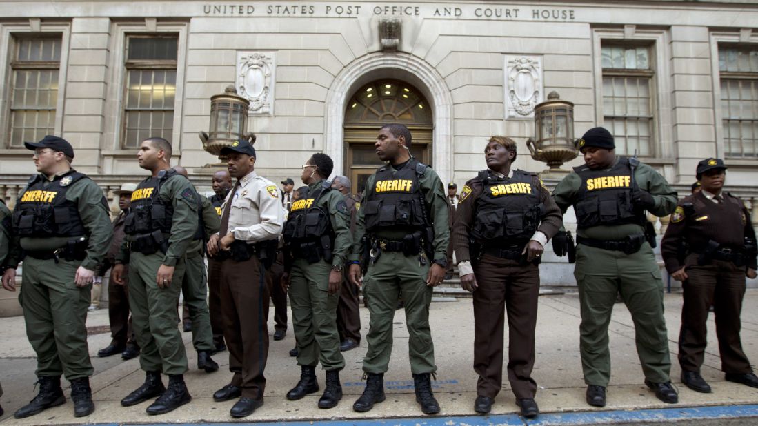 Officers stand guard in front of the courthouse's main entrance as people protest on December 16.