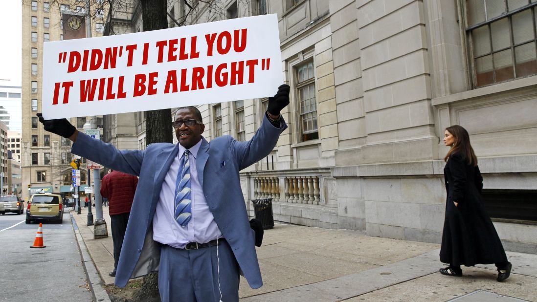 A man displays a sign outside of the courthouse during jury deliberations on December 16.