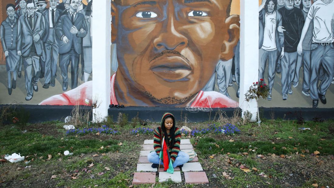 A woman on December 16 sits below a mural depicting Gray at the intersection of his arrest. Bill Murphy, an attorney for the Gray family, stressed that the hung jury doesn't mean Porter's case is over. "I don't buy the nonsense that this is somehow a victory for either side. It's not," he told reporters. "It's just a bump on the road to justice, and you know, the road to justice has lot of bumps."