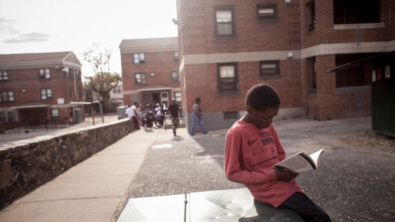 A boy reads a book he picked out during a giveaway organized by members of Out for Justice, a nonprofit advocacy group run by ex-prisoners. The group organizes clothing drives for the poor and a weekly barbecue for the homeless. They are also active in local politics.