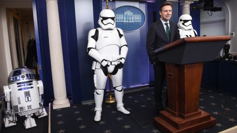 White House press secretary Josh Earnest speaks in the briefing room on December 18, with "Star Wars" characters R2-D2 and Storm Troopers. 