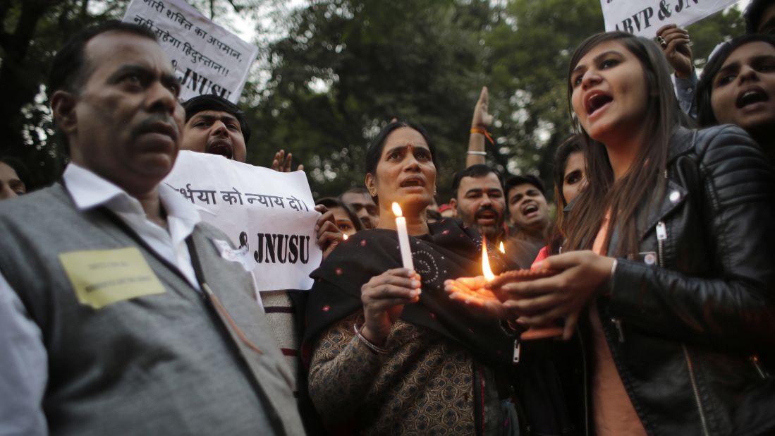 The parents, left and center, of the Indian student victim who was gang raped three years ago join others at a candlelit vigil in New Delhi on December 16.