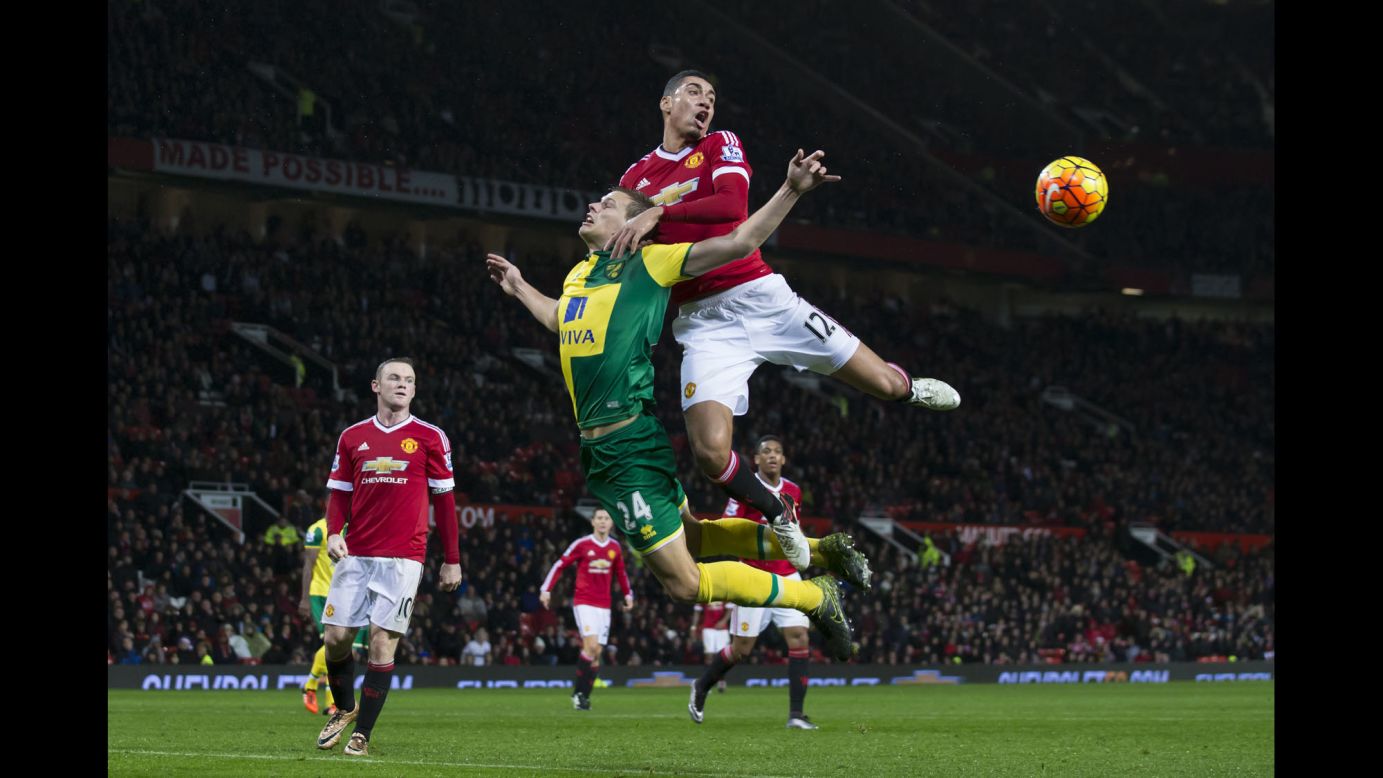 Manchester United's Chris Smalling, top, fights for the ball against Norwich City's Ryan Bennett during an English Premier League soccer match at Old Trafford Stadium in Manchester on Friday, December 19.