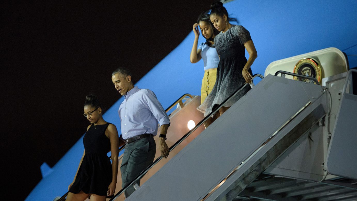 Sasha Obama, from left, President Barack Obama, Malia Obama and first lady Michelle Obama arrive at Hickam Air Force Base in Honolulu on Saturday, December 19.
