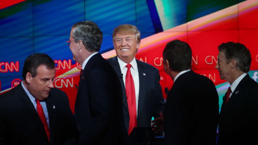 Republican presidential candidate Donald Trump smiles (C) as New Jersey Gov. Chris Christie (L), Jeb Bush (2ndL), Ohio Gov. John Kasich (2nd R) and U.S. Sen. Rand Paul (R-KY) walk onstage afterthe CNN Republican presidential debate on December 15, 2015 in Las Vegas, Nevada. This is the last GOP debate of the year, with U.S. Sen. Ted Cruz (R-TX) gaining in the polls in Iowa and other early voting states and Donald Trump rising in national polls.