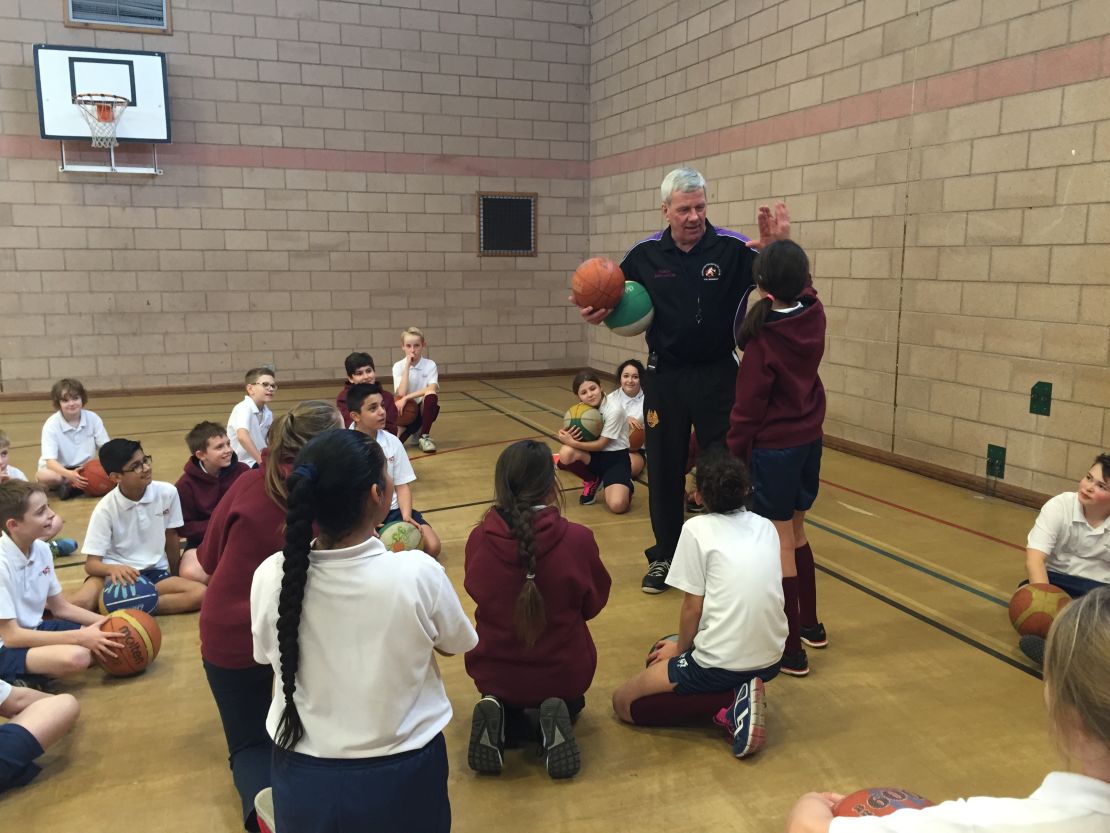 Basketball coach Bob Martin talks to children about the sport.